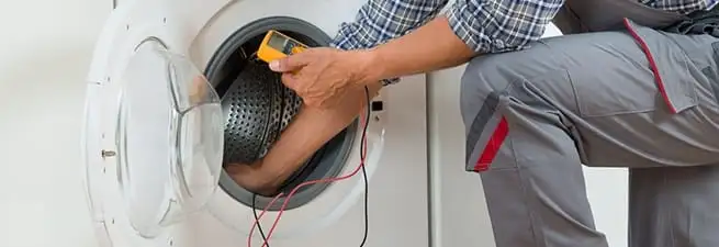 Dryer repair technician inspecting and repairing a clothes dryer in Detroit, MI
