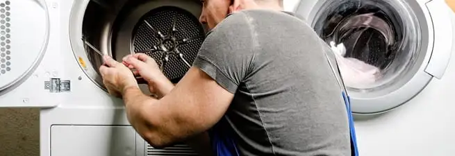 Dryer repair technician fixing a clothes dryer drum in Detroit, MI
