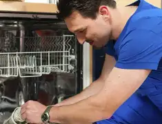 Dishwasher repair technician inspecting and servicing an open dishwasher in Detroit, MI