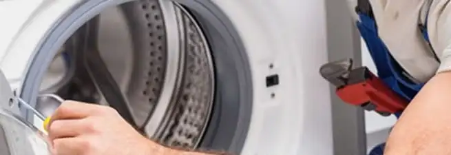 Appliance technician repairing a clothes dryer drum and internal parts in Detroit, MI