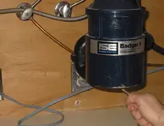 Garbage disposal repair technician tightening the mounting ring under a sink in Detroit, MI