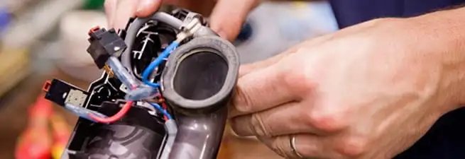Vacuum repair technician reconnecting wiring and components in Detroit, MI