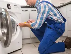Washing machine repair technician servicing a front-load washer in Detroit, MI