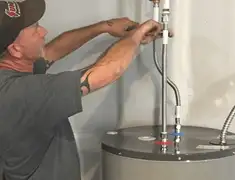 Water heater repair technician tightening supply line connections in Detroit, MI